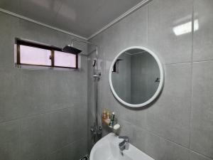 a bathroom with a sink and a mirror at Orasung Motel in Jeju