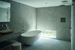 a bathroom with a large tub and a sink at Hiire IZU OMURO in Ito