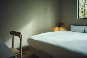 a bedroom with a white bed and a window at Hiire IZU OMURO in Ito