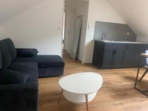 a living room with a couch and a table at location appartement neuf dans maison in Aix-les-Bains