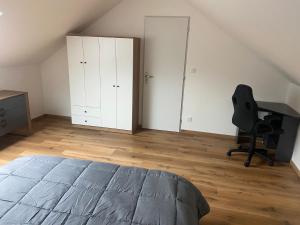 a bedroom with a bed and a desk and a chair at location appartement neuf dans maison in Aix-les-Bains