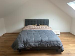 a bed with a blue comforter in a bedroom at location appartement neuf dans maison in Aix-les-Bains