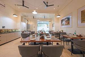 a restaurant with tables and chairs and a kitchen at MAXX Elite in Gurgaon