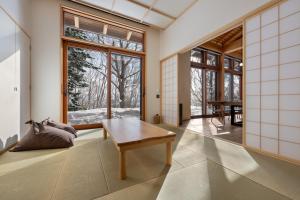 a living room with a table and large windows at Kogetsu To 湖月燈 in Lake Toya +15 photos