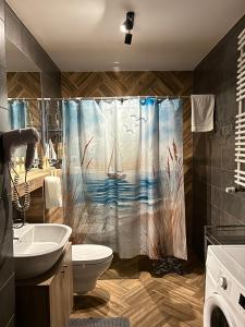 a bathroom with a shower curtain with a sailboat on it at Kurort Kozubnik Daglezja D23 Vista Stay in Porąbka +18 photos