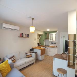 a living room with a couch and a kitchen at Dalgaci Deniz Konukevi in Ayvalık