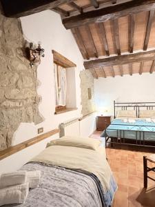 a bedroom with a bed and a stone wall at Agriturismo Casa Paradiso in Cortona