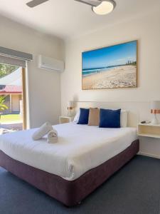 a bedroom with a large bed and a beach at Yamba Motor Inn in Yamba +41 photos