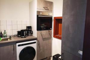 a kitchen with a washing machine and a sink at Ferien- & Monteurwohnung, 5 Betten, WLAN, Parkplatz, Balkon in Nonnendorf