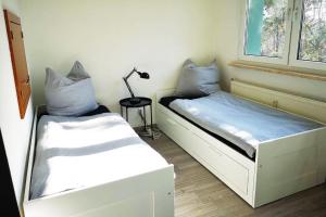 a room with two beds and a lamp in it at Ferien- & Monteurwohnung, 5 Betten, WLAN, Parkplatz, Balkon in Nonnendorf