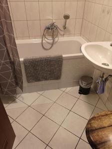 a bathroom with a bath tub and a sink at Ferien- & Monteurwohnung, 5 Betten, WLAN, Parkplatz, Balkon in Nonnendorf