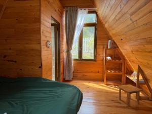 a bedroom with a bed and a window in a cabin at Đồi Lát Homestay in Da Lat