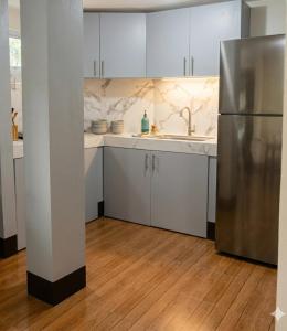 a kitchen with white cabinets and a stainless steel refrigerator at Moalboal Homestay VILLA in Tomonoy