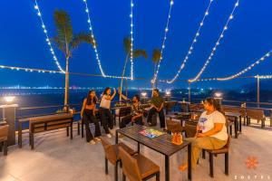 a group of people sitting on a deck at night at Zostel Guwahati in Guwahati