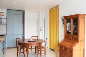 a kitchen with a wooden table and chairs in a room at Renovated studio with quiet balcony in Bois-Colombes