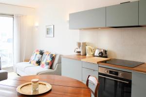 a small kitchen with a wooden table and a tableablish at Renovated studio with quiet balcony in Bois-Colombes
