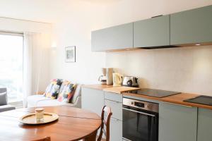 a kitchen with a wooden table and a kitchen with a dining room at Renovated studio with quiet balcony in Bois-Colombes
