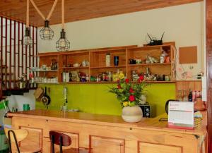 a kitchen with a counter with a vase of flowers on it at Đồi Lát Homestay in Da Lat +34 photos