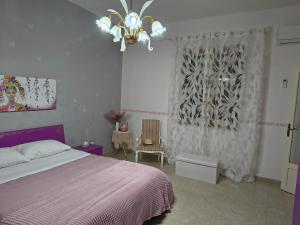ein Schlafzimmer mit einem Bett und einem Kronleuchter in der Unterkunft Casa Vacanze Ciccinè in Capaci
