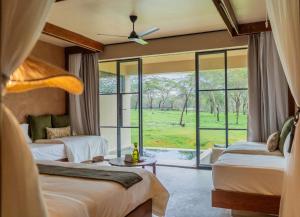 a hotel room with two beds and a large window at Giraffe Manor Tanzania in Usa