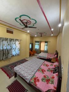 a bedroom with two beds and a ceiling at Naimisharanya Residency in Naimishāranya +19 photos