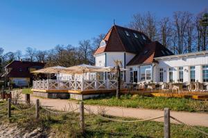 a large white house with tables and chairs in front of it at Hotel Esplanade Resort & Spa - Adults Only in Bad Saarow