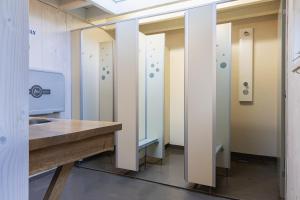 a bathroom with a counter and a row of stalls at Pipowagen in Grashoek
