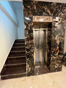 a staircase in a building with a glass elevator at Cherry Blossom in Varanasi
