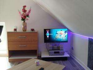 a living room with a television and a dresser at le petit cosy terrasse et spa in Petersbach