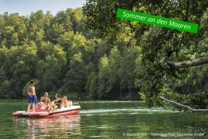 a group of people riding on a pink raft in the water at Haus Alleegarten in Bad Bertrich