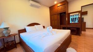 a bedroom with a bed with a towel on it at Kamala Garden Bungalows in Kamala Beach