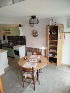 a kitchen with a wooden table and chairs in a room at le petit cosy terrasse et spa in Petersbach