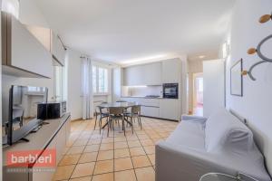a kitchen and living room with a couch and a table at Residence La Rotonda in Cervia