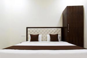 a bedroom with a large bed with a wooden headboard at Hotel Savera Amritsar Near Golden Temple in Amritsar