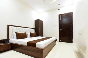 a bedroom with a bed and a wooden door at Hotel Savera Amritsar Near Golden Temple in Amritsar +18 photos