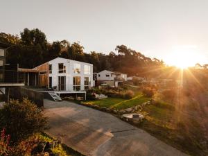 an aerial view of a house with the sun setting at Tasman Tides - Architecturally-designed holiday home in Eaglehawk Neck