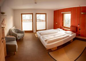 a large bedroom with a large bed and a chair at Soami Spaces - Alpine Hideaway in Millstatt +29 photos