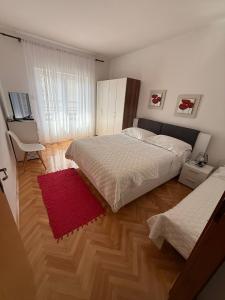 a bedroom with a bed and a red rug at Villa Brajković in Vodice +47 photos