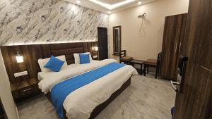 a hotel room with a large bed with blue pillows at Cherry Blossom in Varanasi
