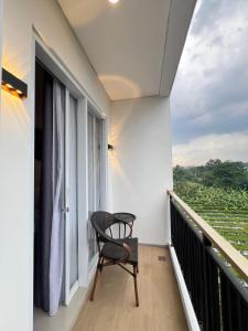 a chair sitting on a balcony with a window at Front One The Andia Boyolali in Boyolali