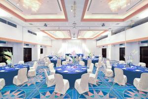 a banquet hall with blue tables and white chairs at Hotel Sekumiya in Obama