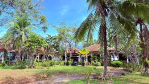 a house with palm trees in front of it at Kamala Garden Bungalows in Kamala Beach