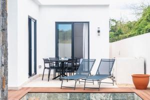a dining room with chairs and a table on a patio at Mango House - 2 Bedrooms & Private Pool in La Gaulette