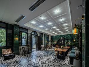 a lobby of a hotel with tables and chairs at La MAISON Banshan in Chongqing