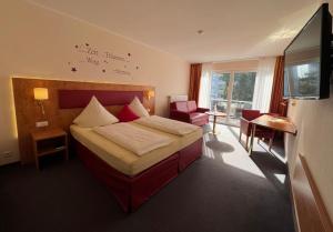 a hotel room with a bed and a desk at Hotel Häfner in Bad Schonborn +50 photos