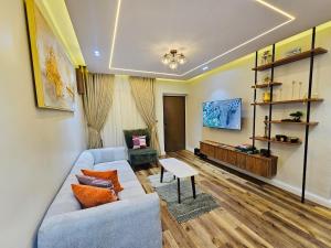 a living room with a blue couch and a table at Luxe Flat Light in Mama