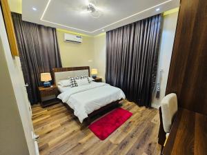 a bedroom with a large bed and a red rug at Luxe Flat Light in Mama