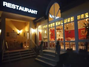 a restaurant with a sign on the front of it at night at Hotel Goldbächel in Wachenheim an der Weinstraße