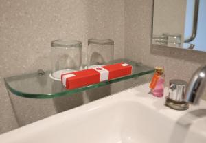a glass shelf over a sink with a toy train on it at Amaris Hotel Bekasi Barat in Bekasi