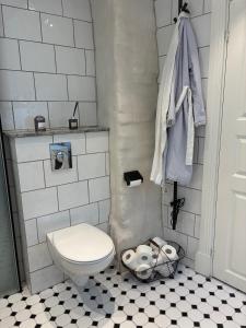a bathroom with a white toilet and a black and white floor at Fiskargränden, Landskrona in Landskrona +12 photos